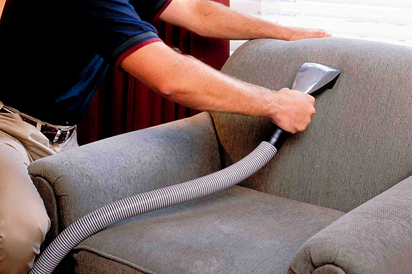 A man cleaning an armchair.