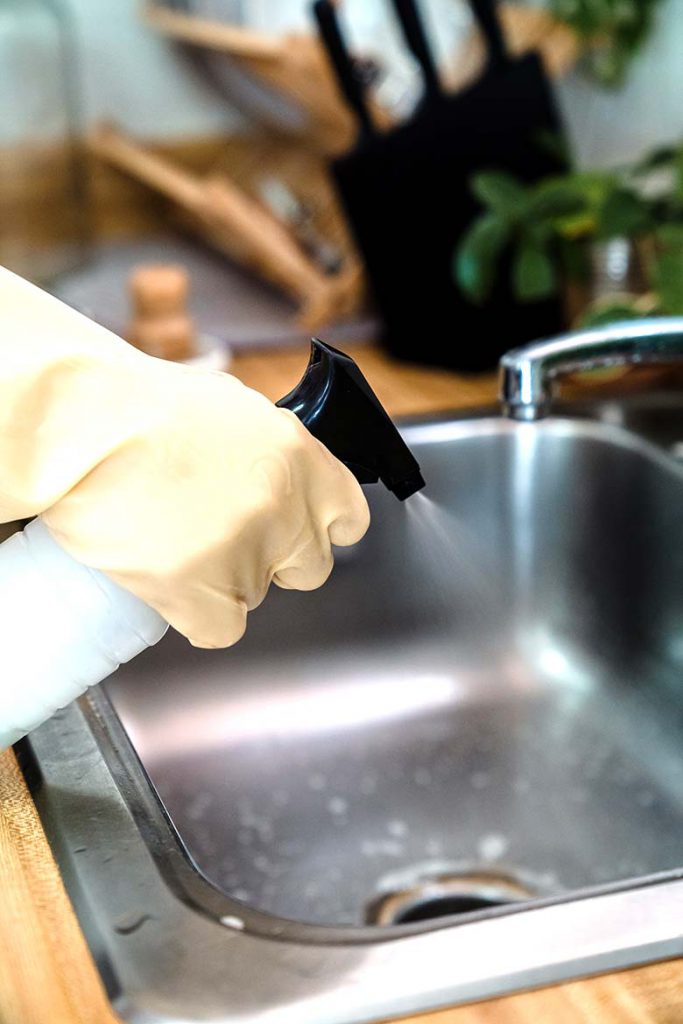 A kitchen sink being cleaned.